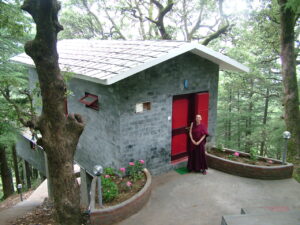 Geshe Kelsang Wangmo in front of one of our new retreat huts